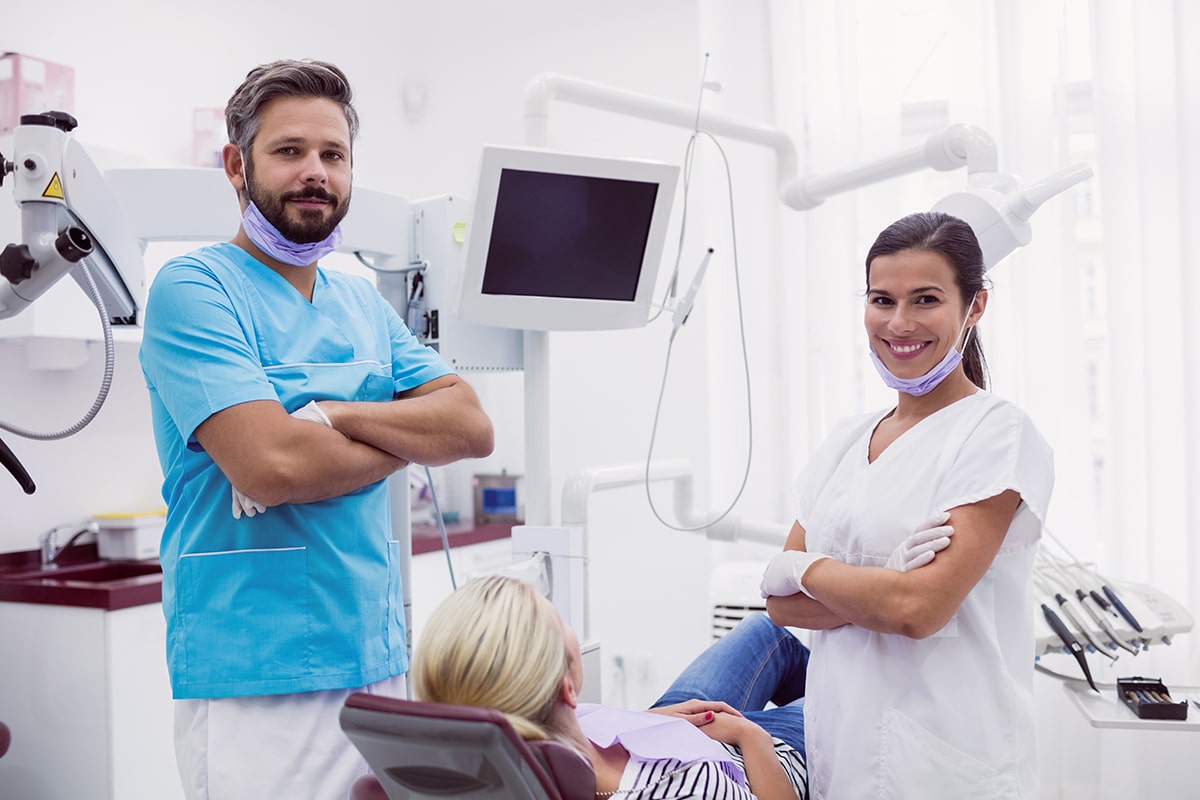 A photo of two dentists and a patient