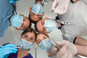 Five dentists looking at a patient